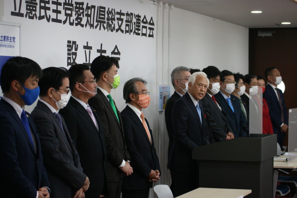 演壇であいさつする塚本久愛知県連幹事長(中央) 塚本幹事長.JPG