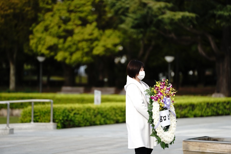 出発式前、平和記念公園で慰霊碑を参拝、献花する宮口候補 0408告示日@旧市民球場跡地前_210408献花.jpg