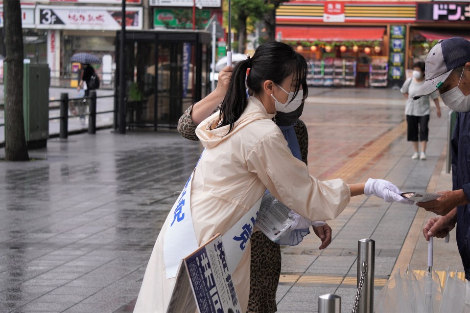 一人ひとりにチラシを渡し、あいさつする斉藤さん ★チラシ配る斉藤さんjpg.jpg