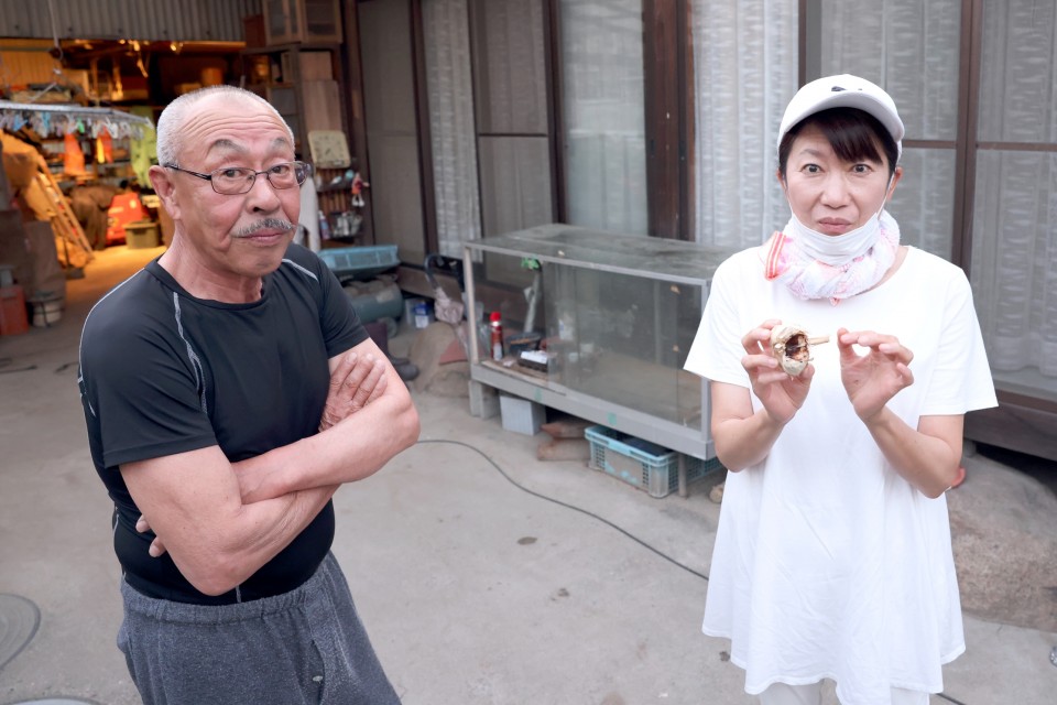 はた総支部長の狩猟(わな)の師匠(左)と、イノシシ肉と一緒にいただいた黒にんにくを手にするはた総支部長(右) はたともこ